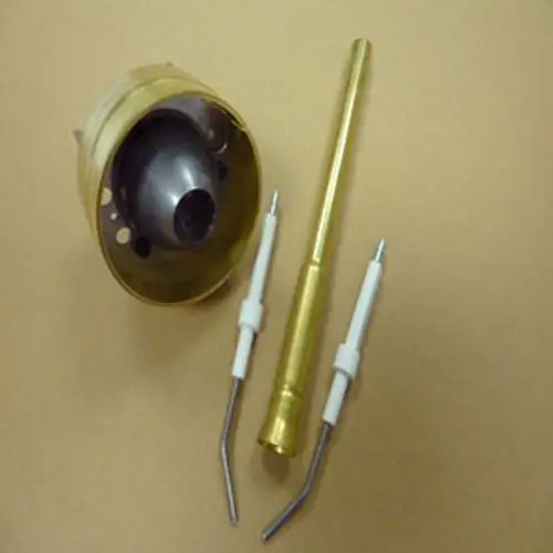 Zubehörteile von Remeha, bestehend aus einem metallischen Kopfteil, einem langen Rohr und zwei gebogenen Drähten, angeordnet auf einem neutralen Hintergrund.
